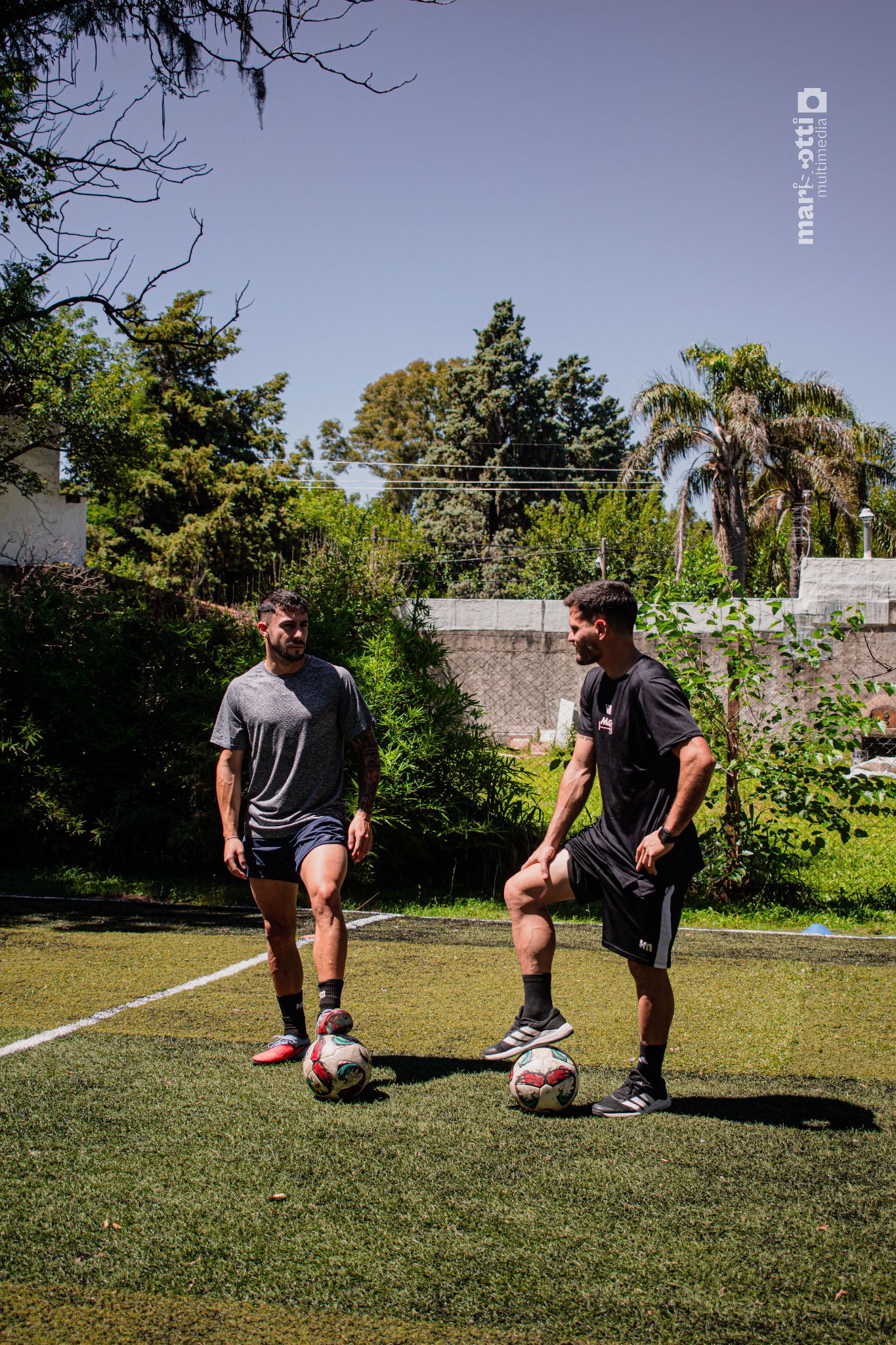 Preparador físico y futbolista durante una tarea con pelota